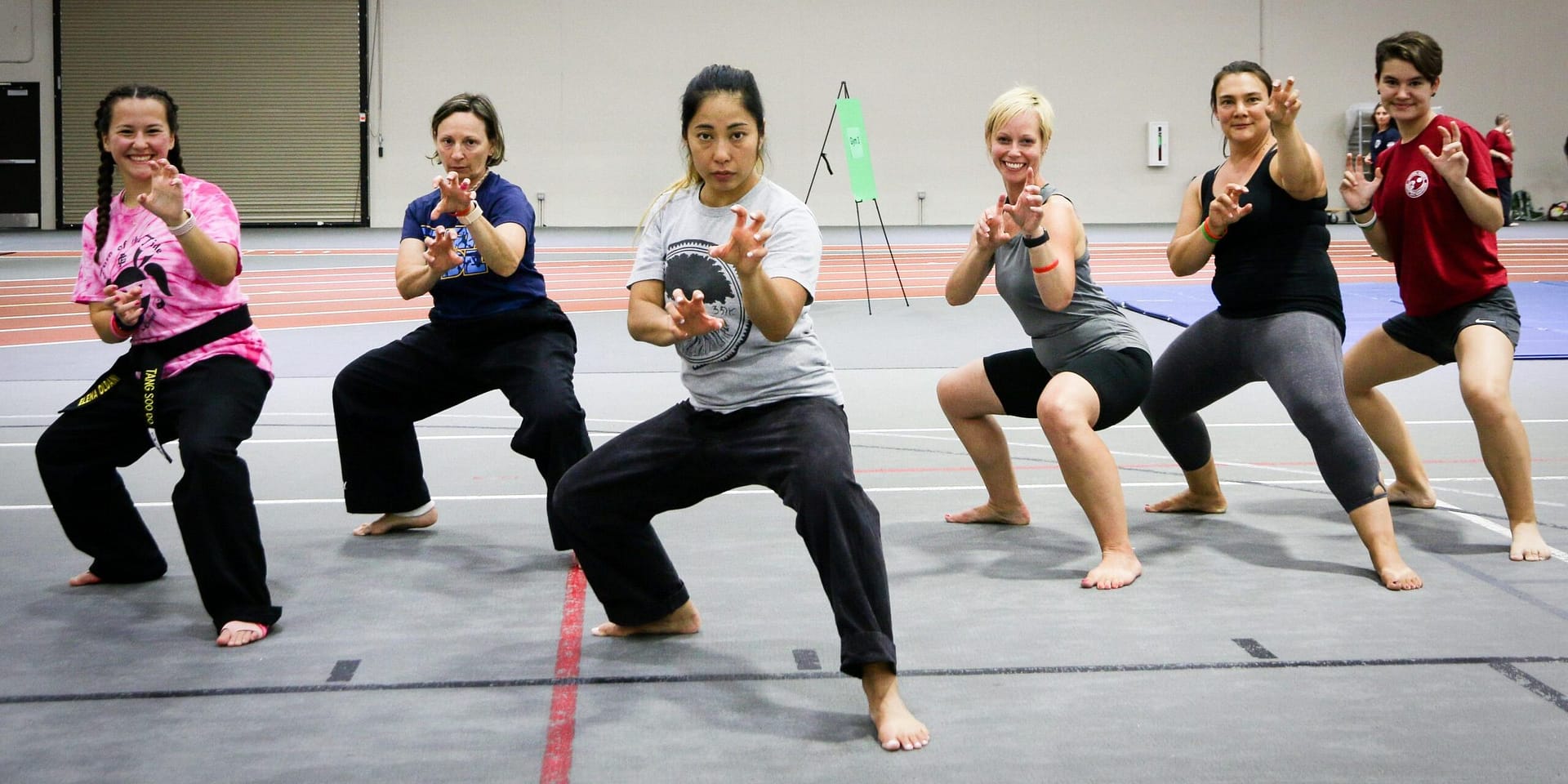 women martial artists lined up in a fighting stance