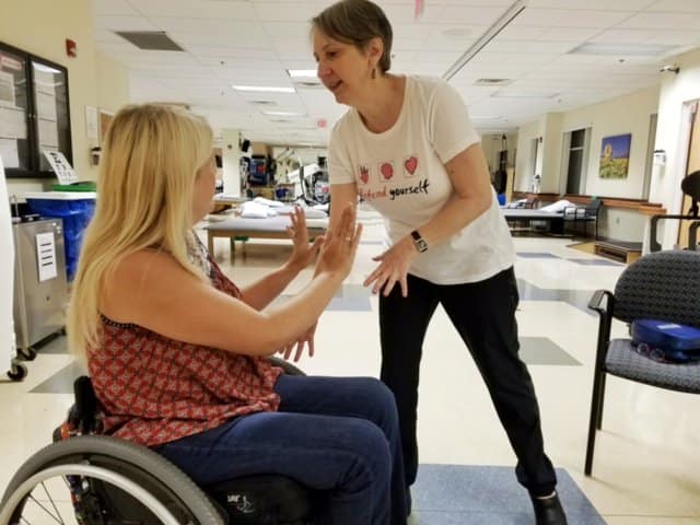 person in a wheelchair practicing setting a boundary with instructor