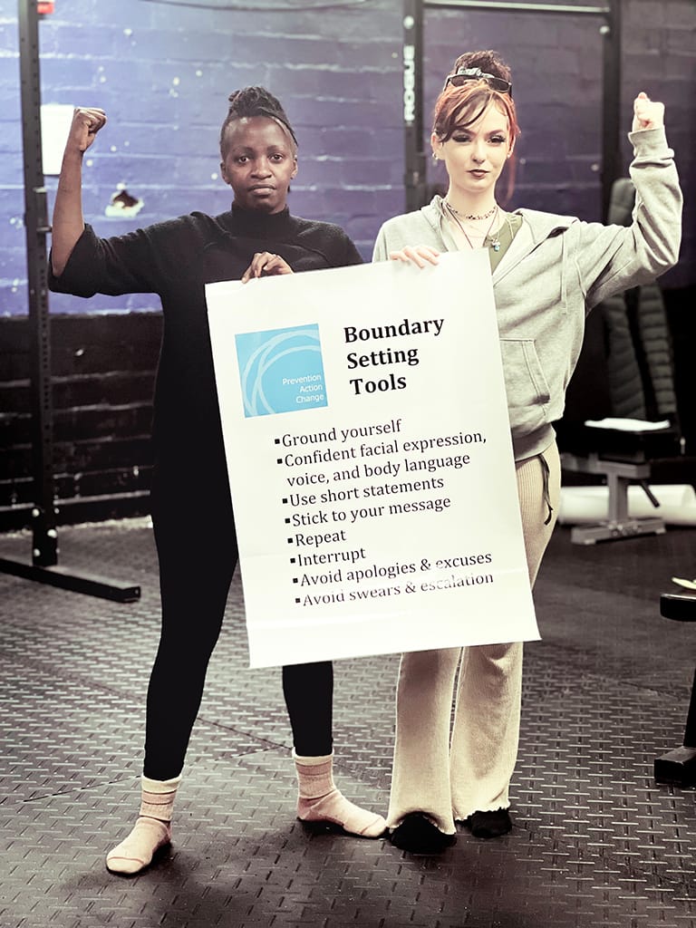two women holding up a poster 